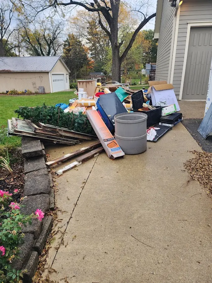 Dumpster being loaded with debris for Estate Cleanout Dumpster Rental in Three Lakes